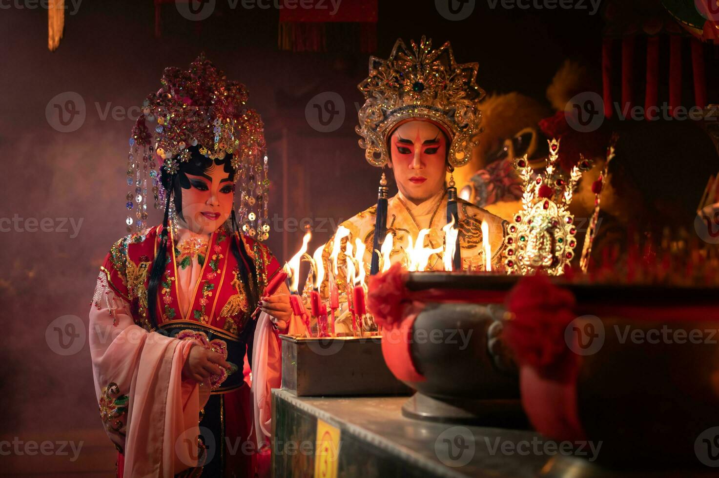 manlig och kvinna kinesisk opera aktörer ljus en ljus till be hyllning till de gudar till förbättra de välstånd för själv på de tillfälle foto