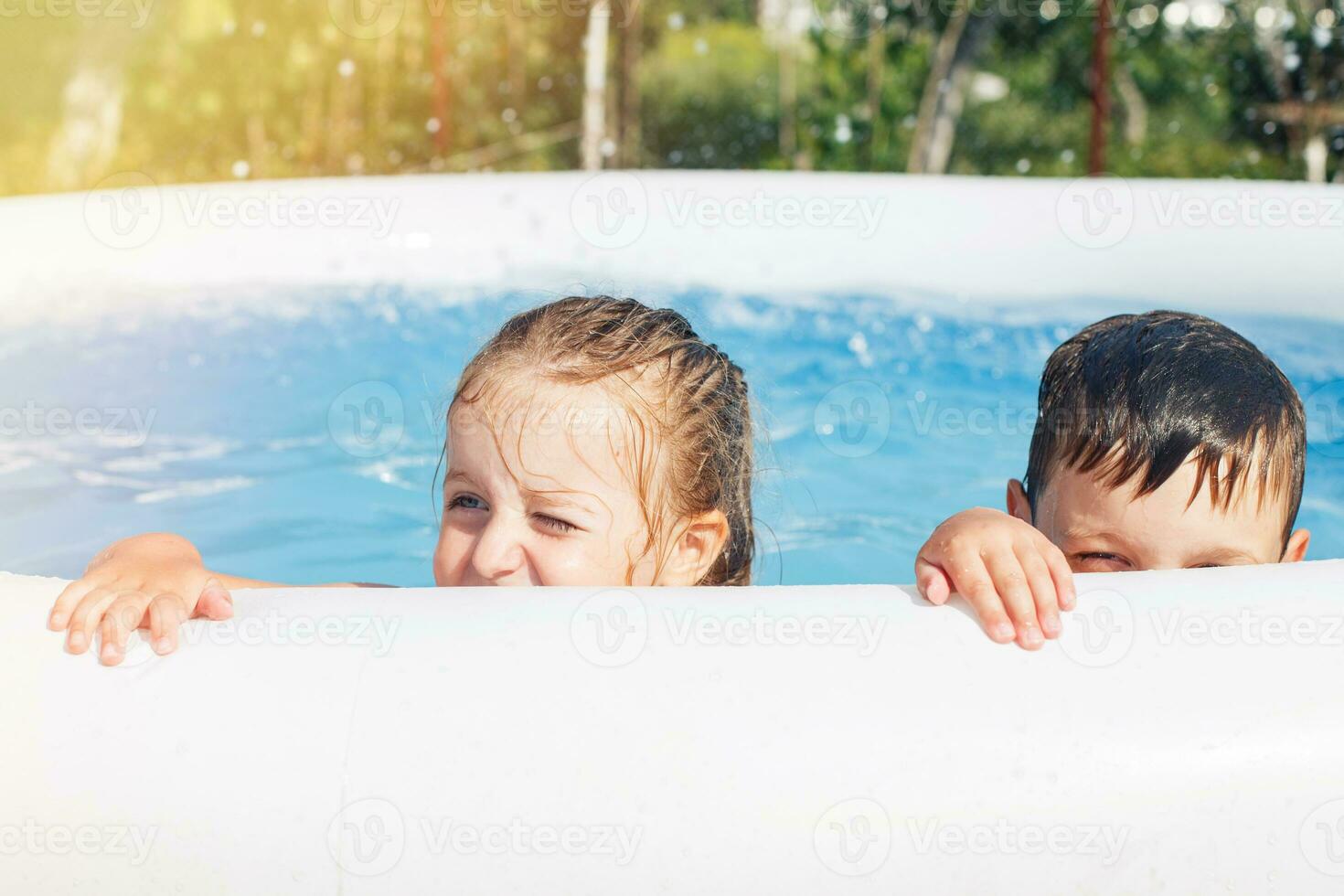 porträtt av Lycklig pojke och flicka i de slå samman i de trädgård på sommar foto