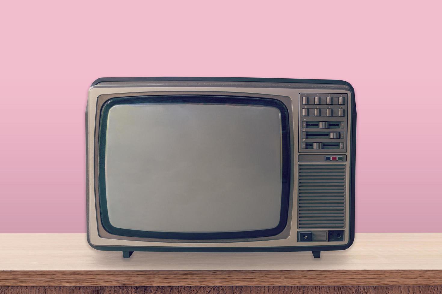 årgång TV låda på trä- tabell och rosa pastell Färg bakgrund. foto