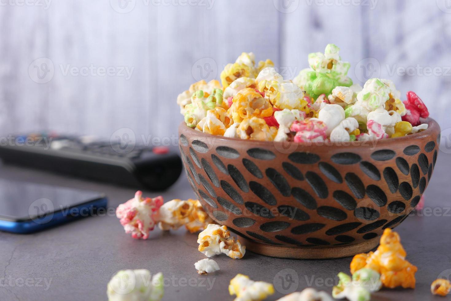 popcorn i en skål på träbord foto