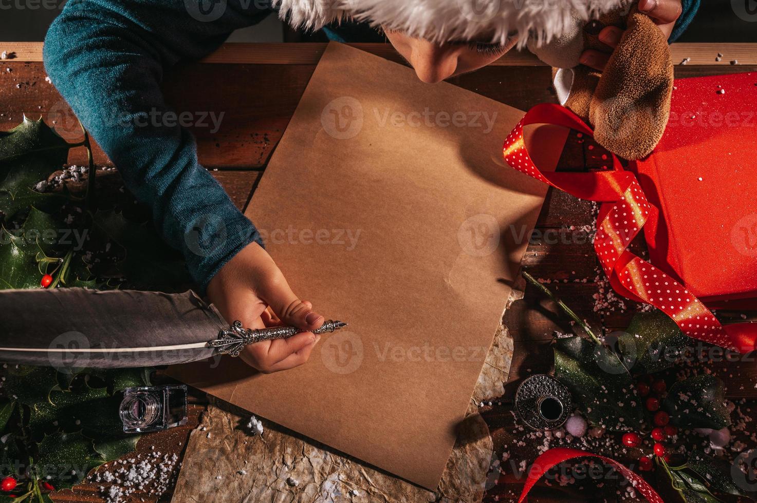 barn med jul hatt skrivningar en brev till santa claus för gåvor foto