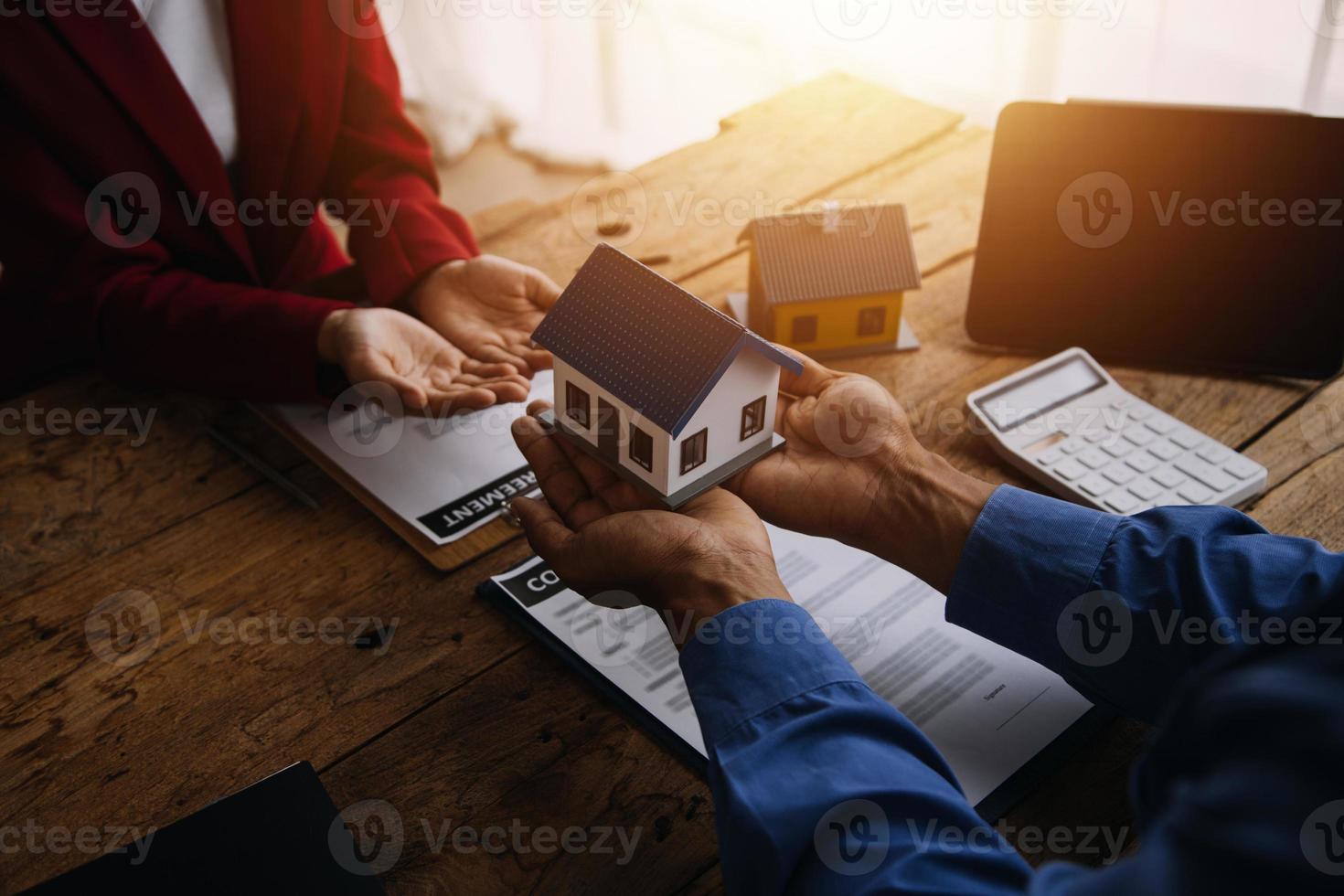 fastighetsmäklare presenterar och rådgör med kund till beslutsfattande teckna försäkringsformulär avtal, köp och sälj bostadsmodell, gällande bolåneerbjudande för och villaförsäkring foto