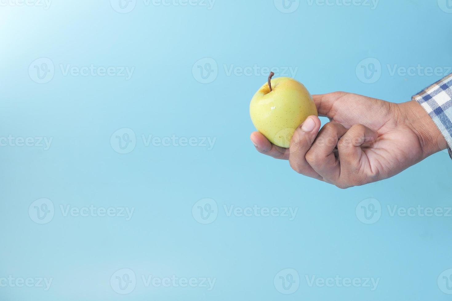 grönt äpple på blå bakgrund foto