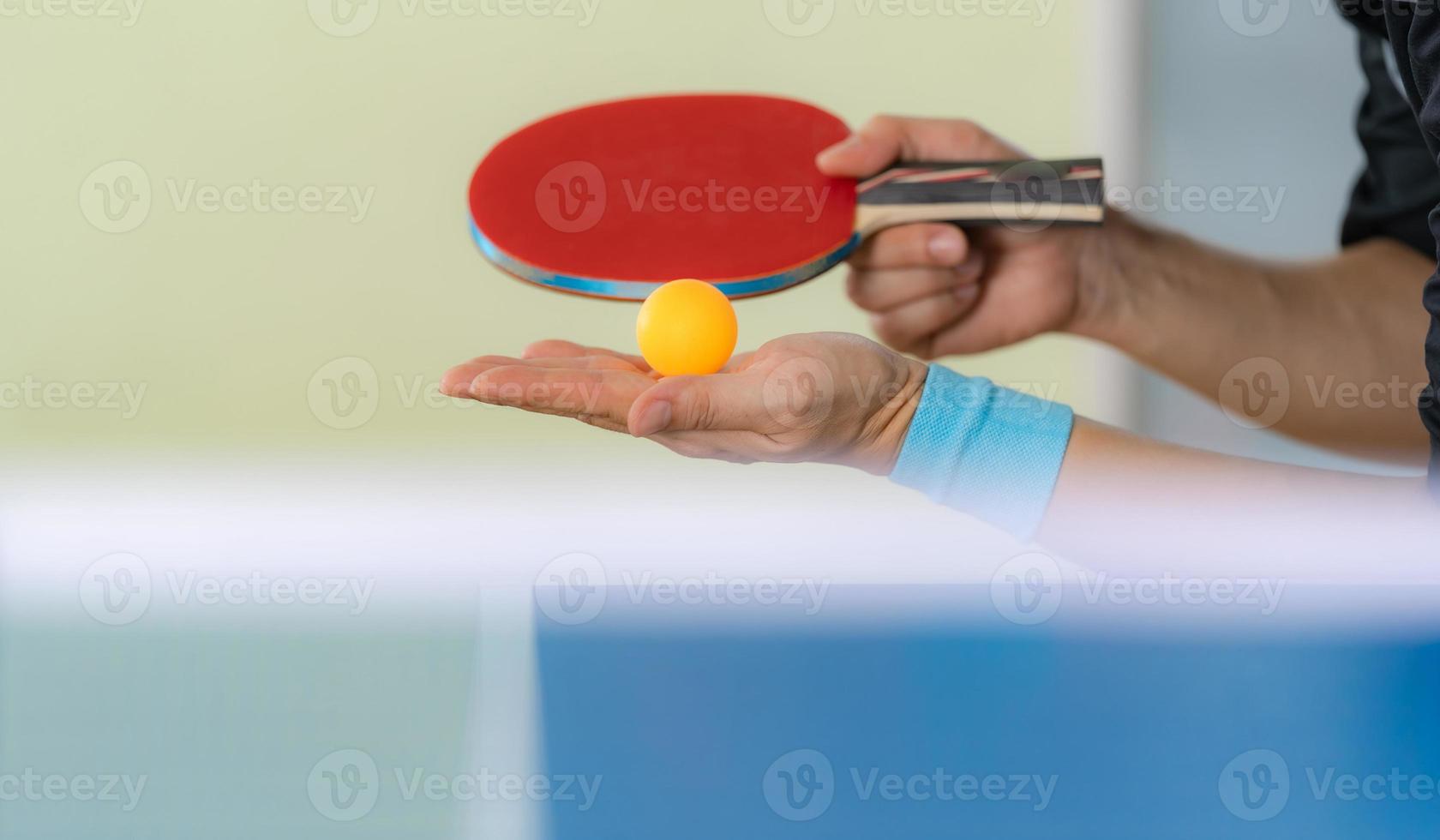 man spelar bordtennis med racket och boll i en sporthall foto