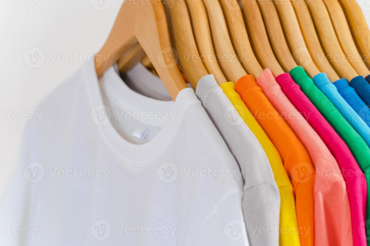 närbild av t-tröjor på galgar, klädbakgrund foto
