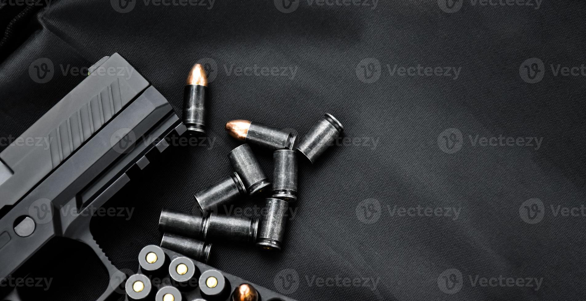 automatisk svart 9mm pistol och kulor på svart läder bakgrund, selektiv och mjuk fokus, kopia Plats. foto