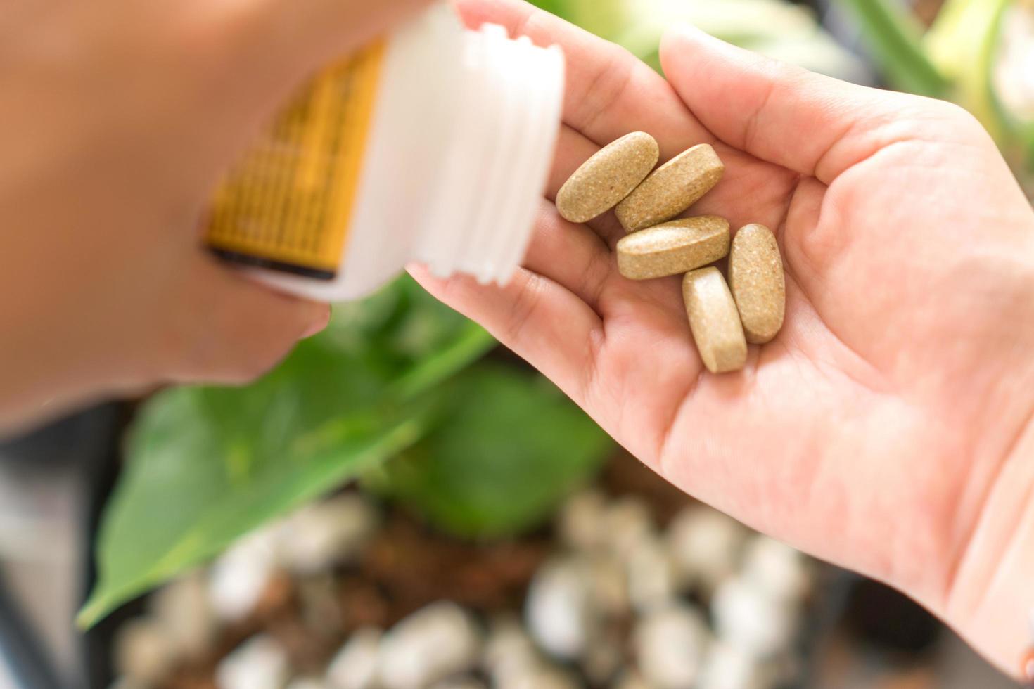 ovanifrån av alternativ organisk medicin tablett på kvinnans hand foto