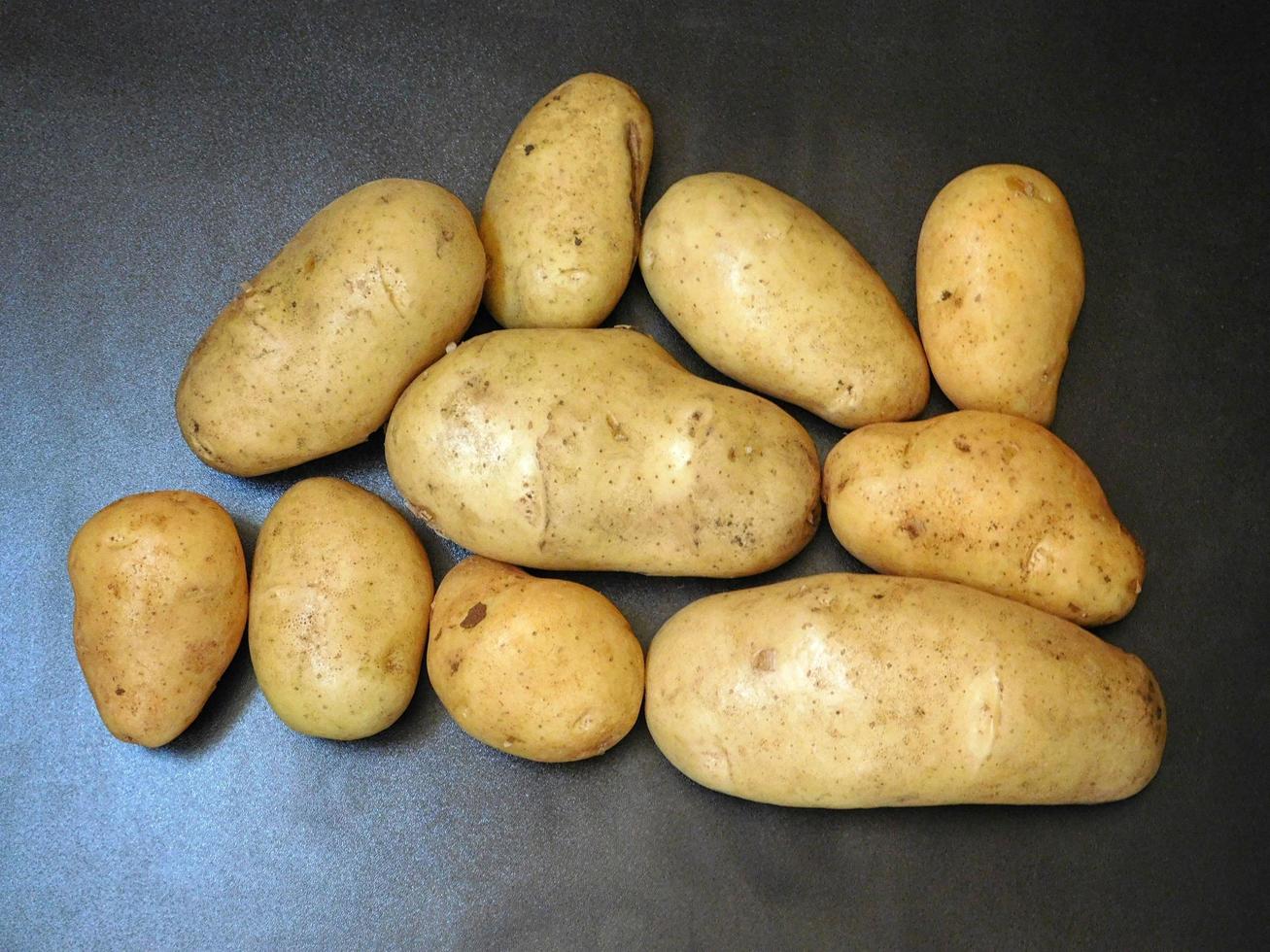 potatis på en mörk bordsbakgrund foto
