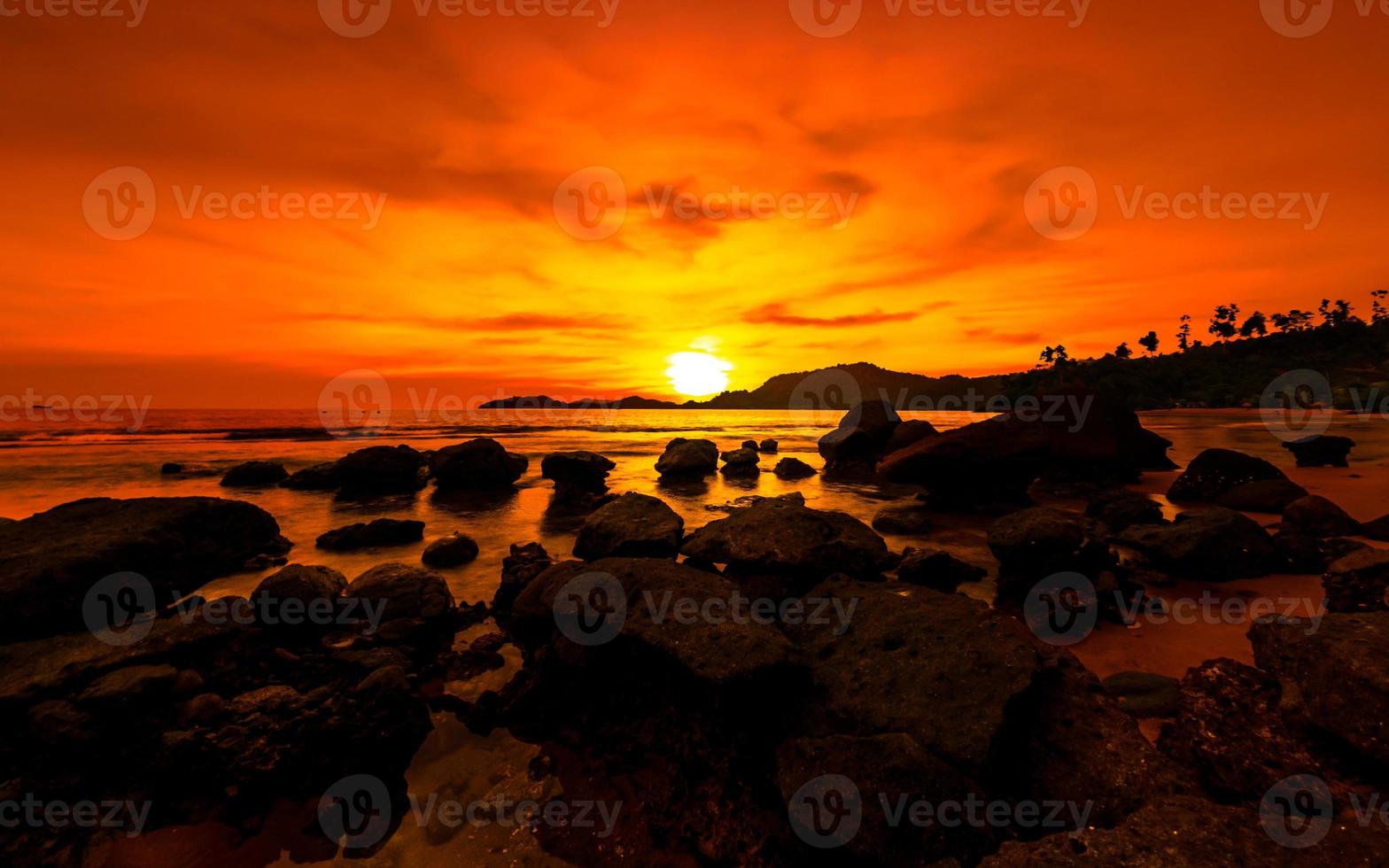 gyllene timme solnedgång. orange solnedgång på havet med stenar foto