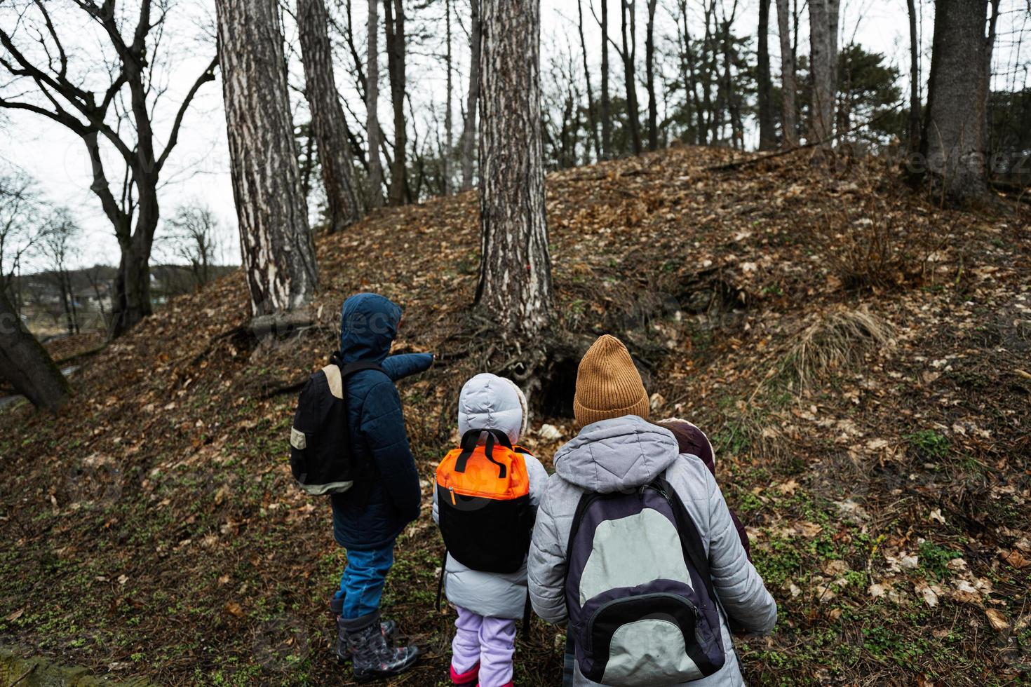 mor och barn gående i skog, lagt märke till ett djur- håla. foto