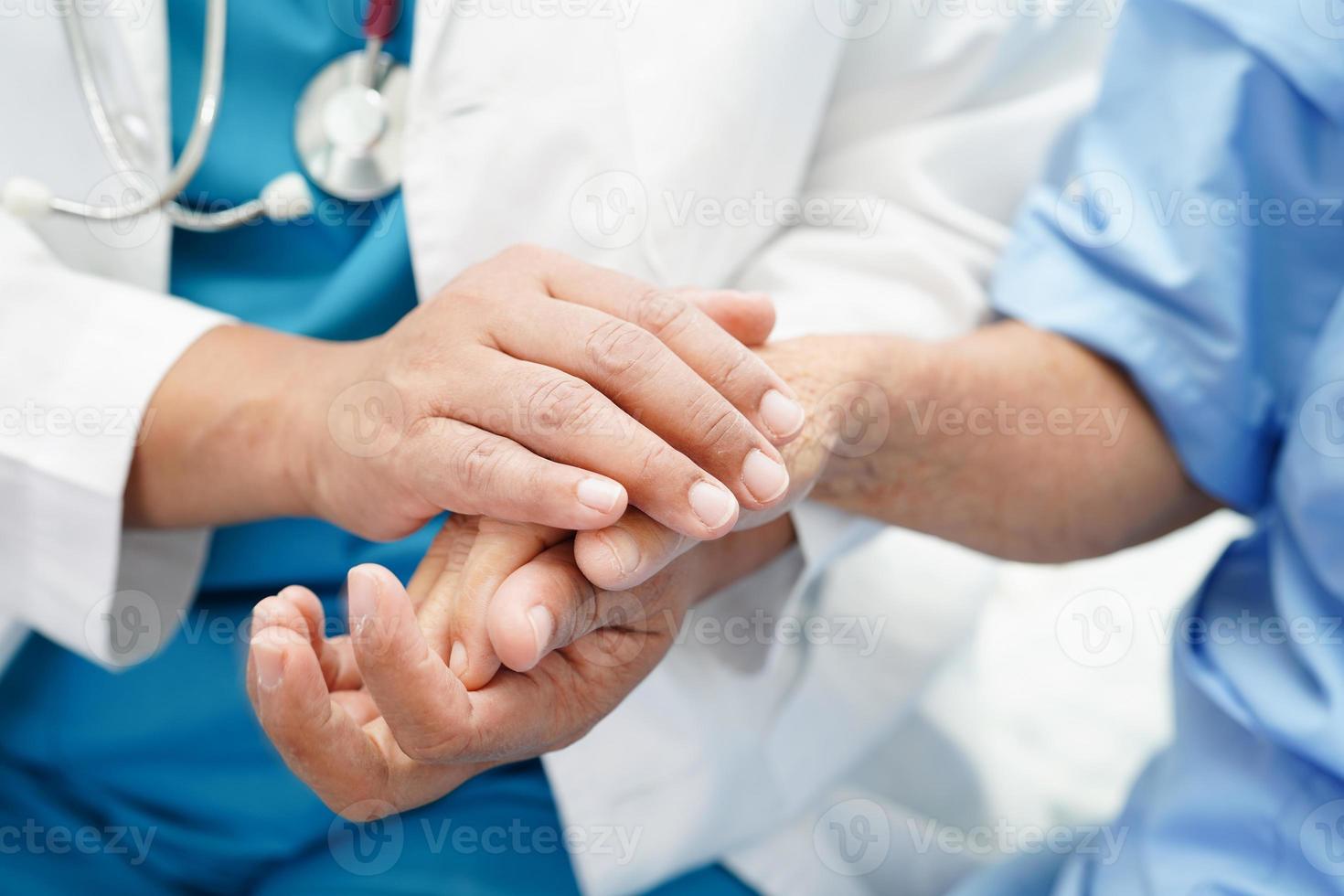 läkare som tar hand om, hjälper och uppmuntrar asiatisk äldre äldre kvinna patient på kliniken sjukhus. foto