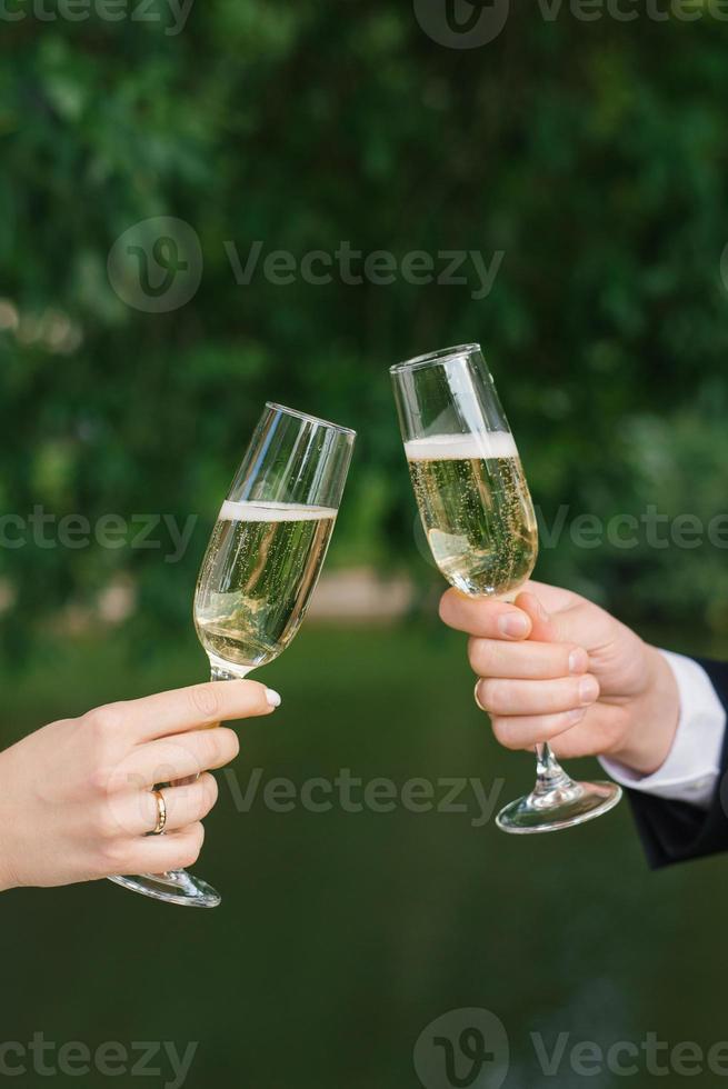 de brud och brudgum är innehav två champagne glasögon för de bröllop ceremoni foto