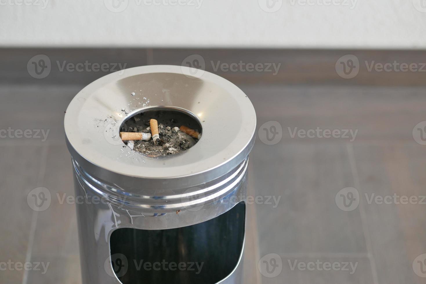 närbild brinnande cigarett i askkopp på bordet foto