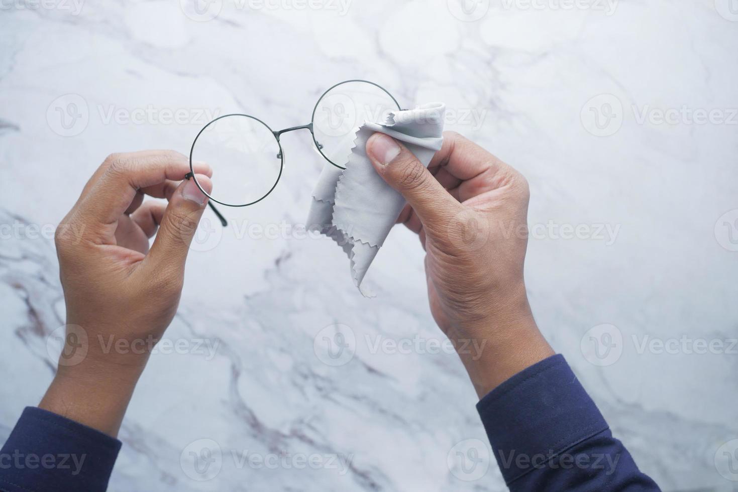 rengöring glasögon med vävnad närbild foto