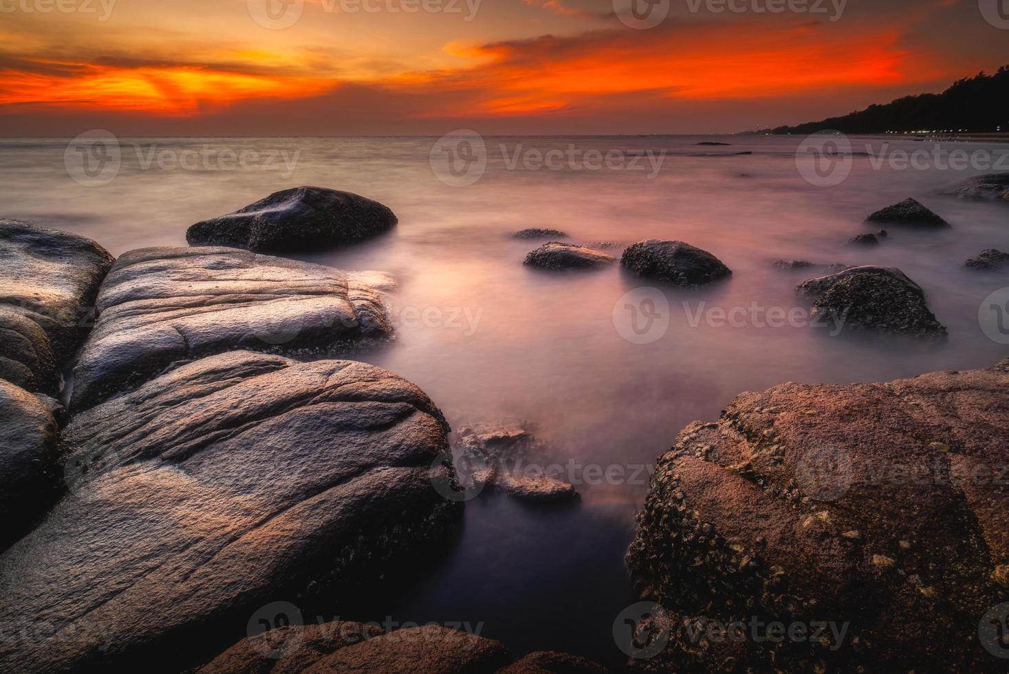 strand och stenar på solnedgång foto