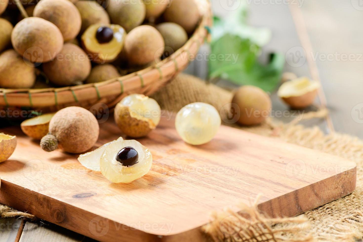 färsk longan frukt på trä tallrik och gammal trä bakgrund, foto