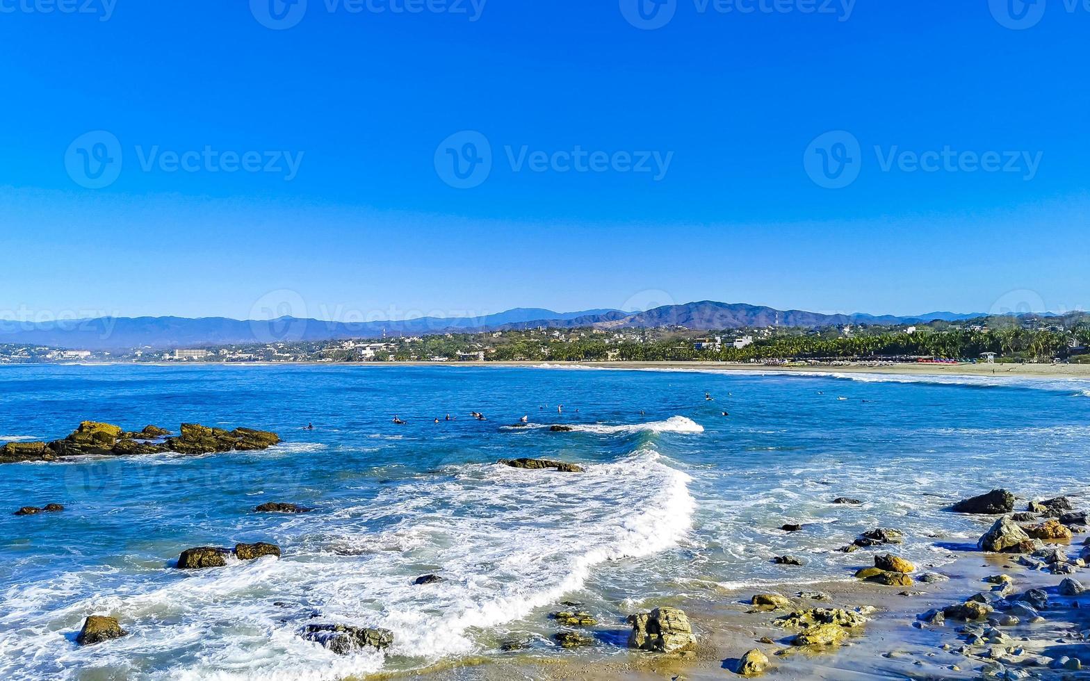 skön stenar klippor surfare vågor på strand puerto escondido Mexiko. foto