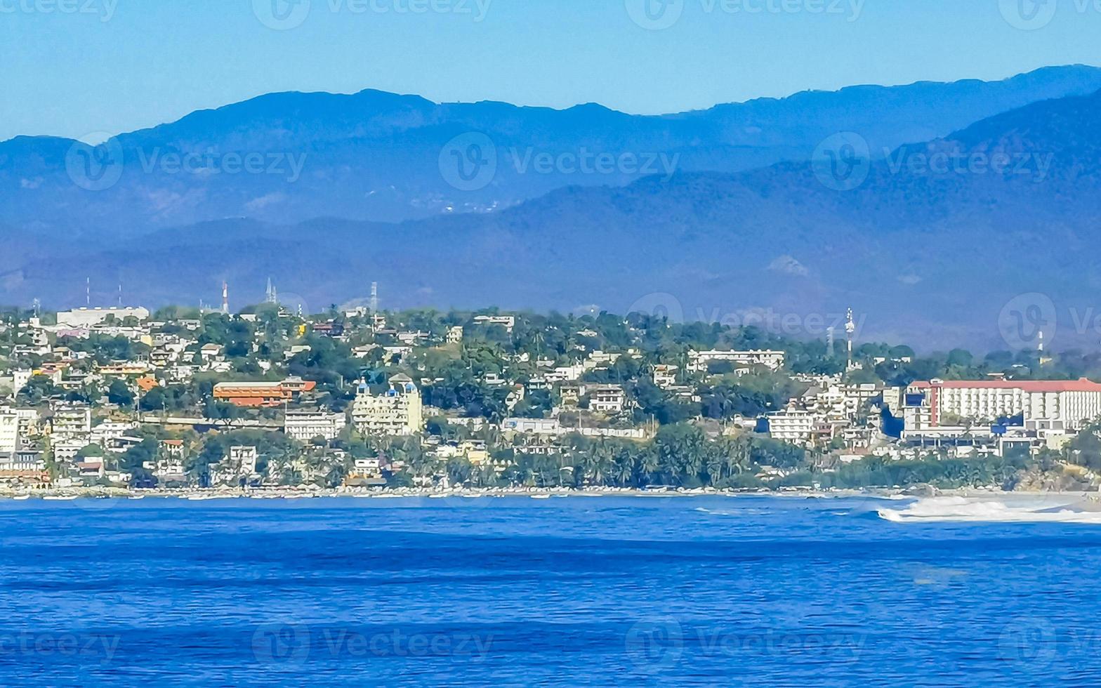 Sol strand klippor stenar vågor palmer bergen puerto escondido Mexiko. foto