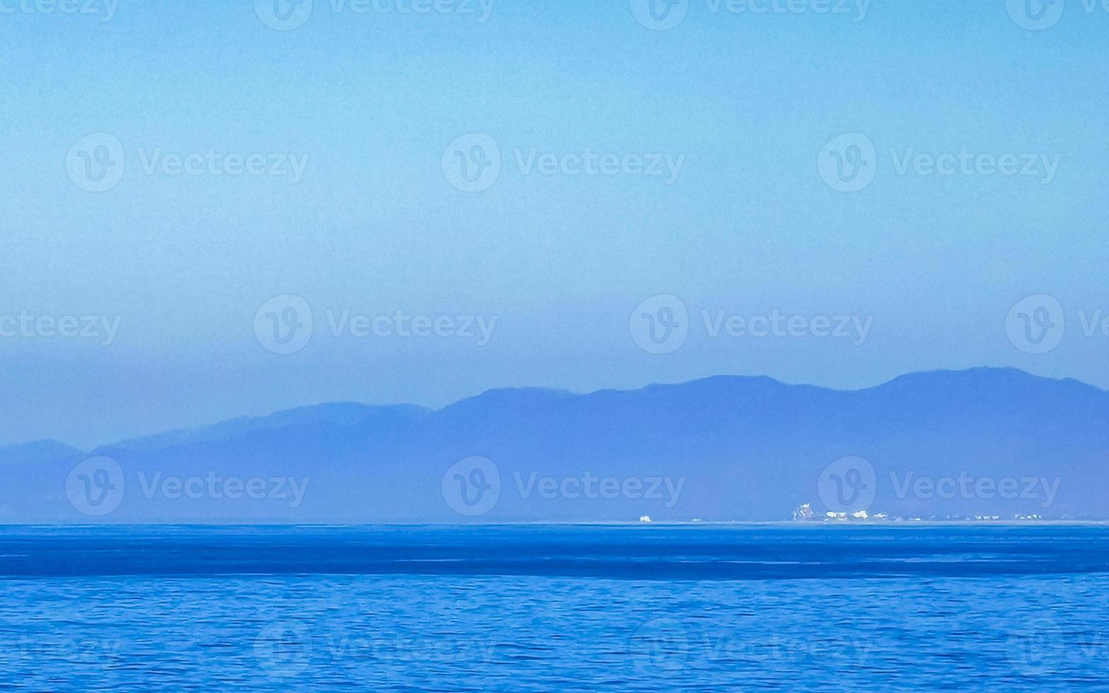 Sol strand klippor stenar vågor palmer bergen puerto escondido Mexiko. foto