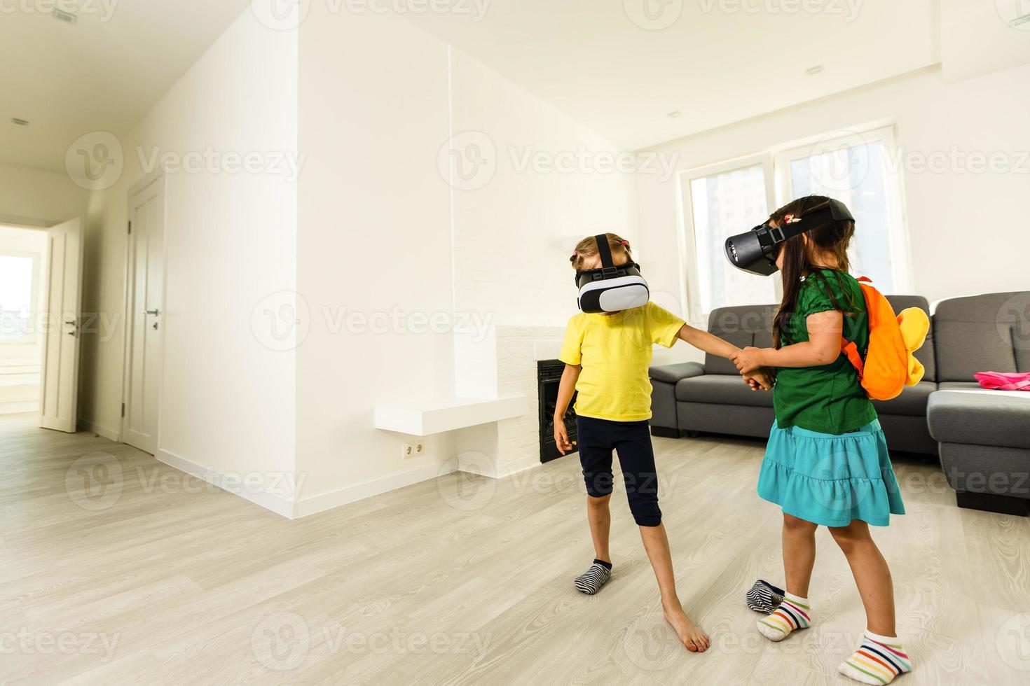 barn med virtuell verklighet headsetet och joystick spelar video spel foto