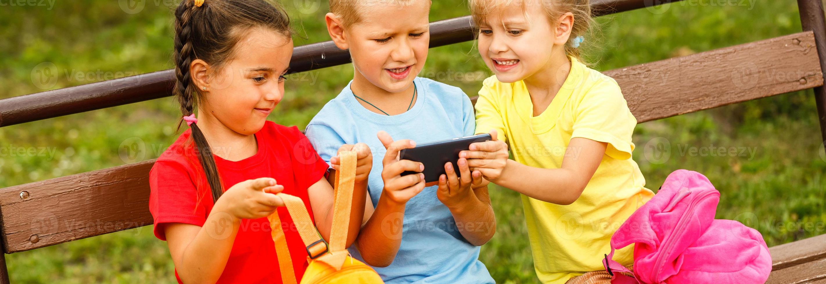 Lycklig barn tar en selfie med smart telefon. teman vänskap, sommaren och modern teknologi foto