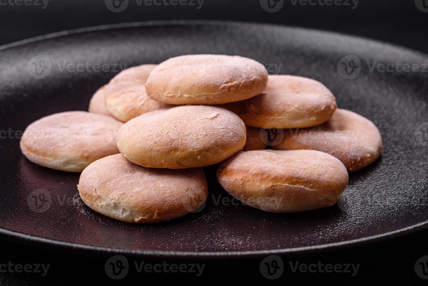 utsökt färsk bakad majsmjöl shortcakes eller småkakor på en svart tallrik foto