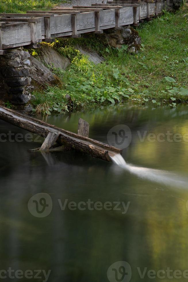 en små damm med en kanal var vatten kör genom foto