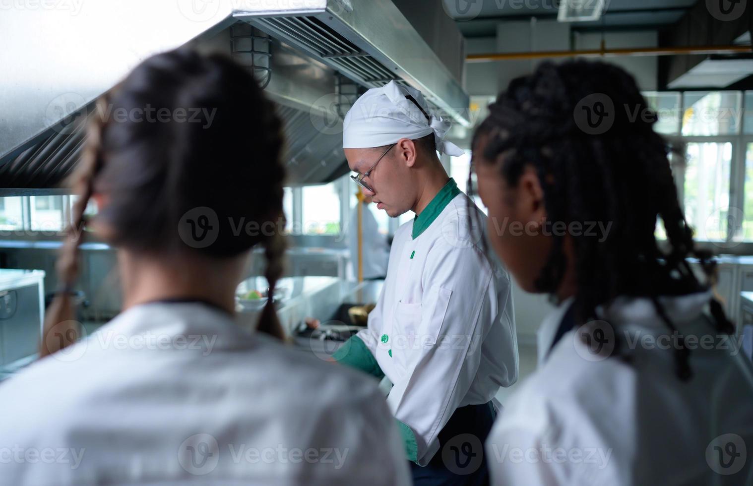 ung kock, universitet professor är godkänd på de kunskap av matlagning till studenter foto