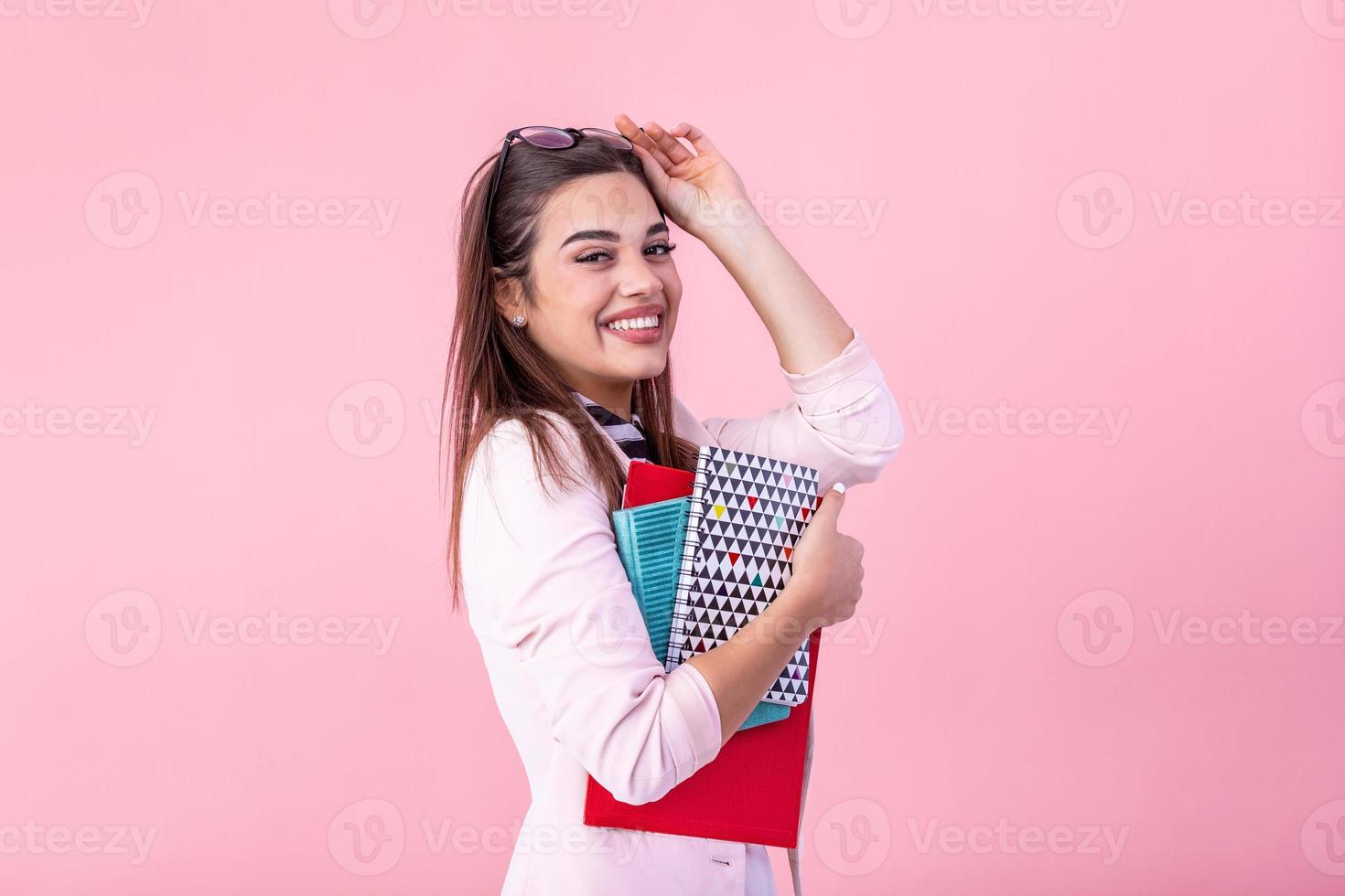 ung flicka tonåring studerande innehav böcker isolerat på rosa bakgrund studio porträtt. utbildning i hög skola universitet högskola begrepp. foto