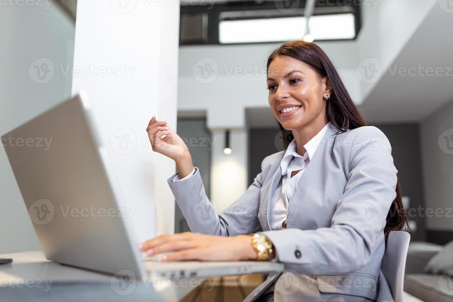 ung kvinna arbetssätt från Hem, medan i karantän isolering under de covid-19 hälsa kris. porträtt av en skön ung företag kvinna leende och ser på bärbar dator skärm foto