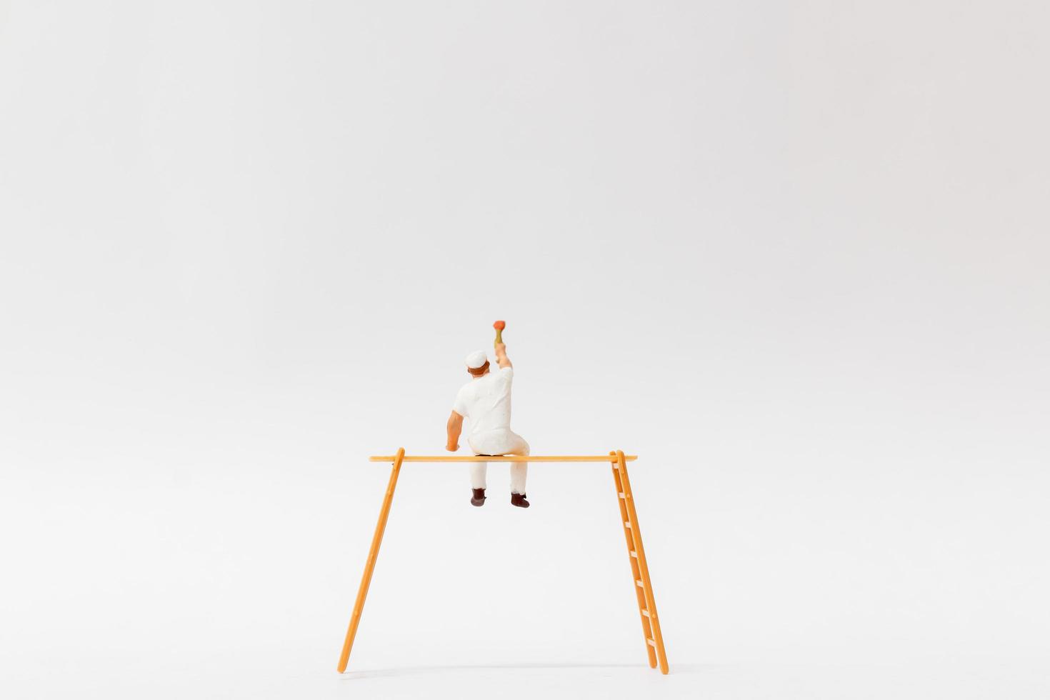 miniatyrmålare som håller en borste på en vit bakgrund foto