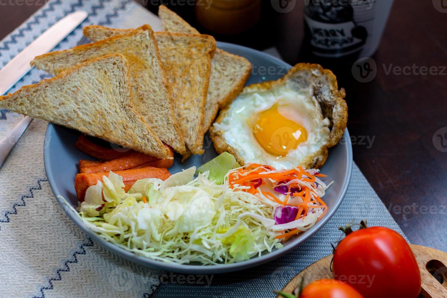 frukost, friterad ägg, friterad korv, vegetabiliska sallad och rostat bröd på en brun trä- tabell med kaffe. foto