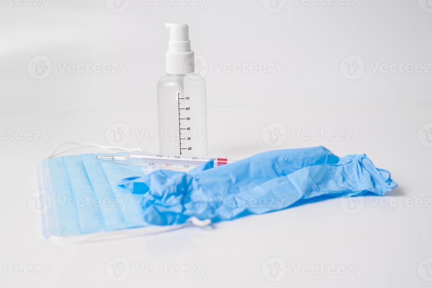 kirurgisk mask med handskar, termometer och desinfektionsmedel foto
