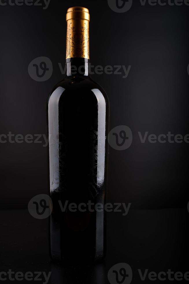 vinflaska med svart bakgrund foto