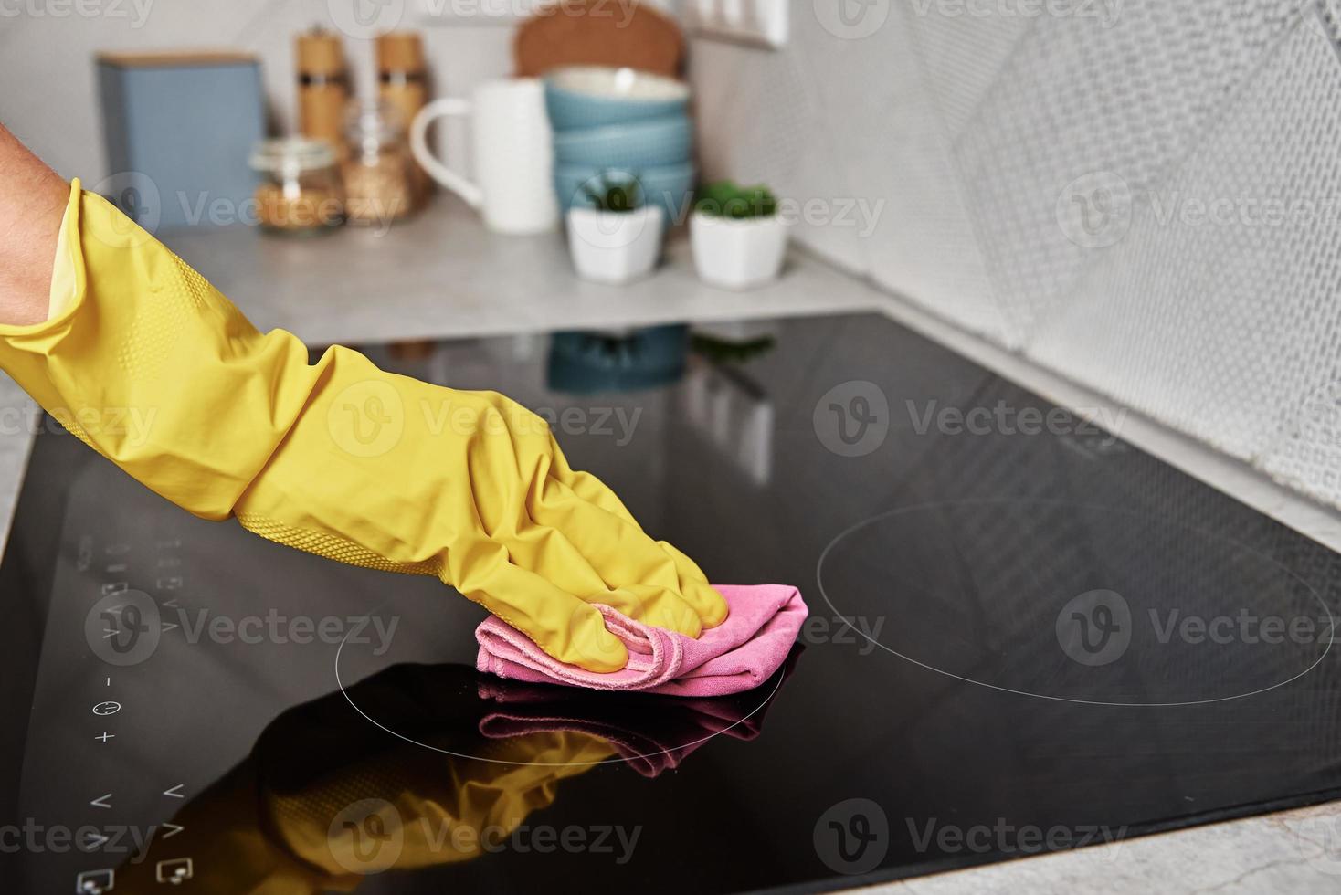 kvinna i sudd handskar rengöring induktion spis foto