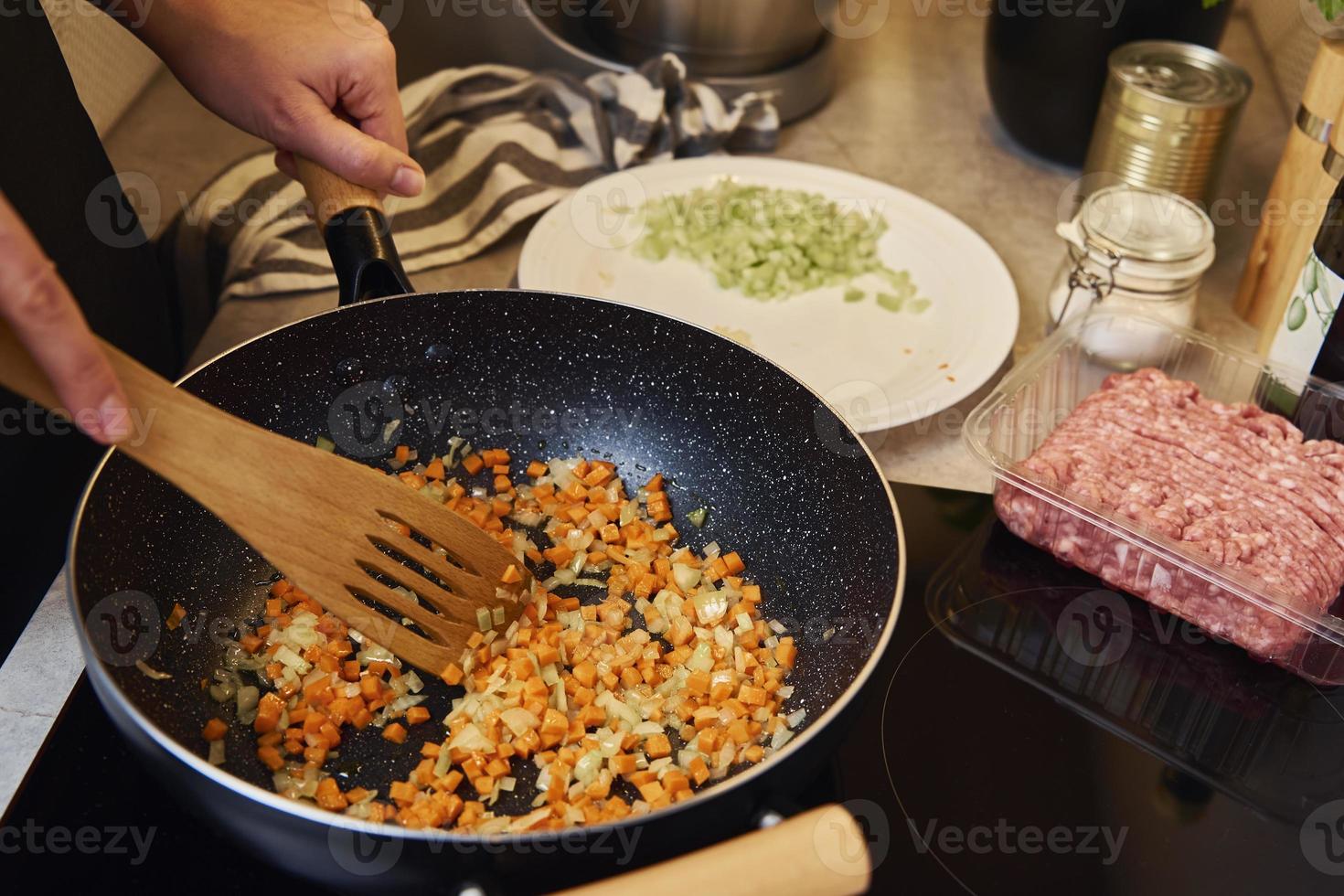 kvinna matlagning sås bolognese i kök foto