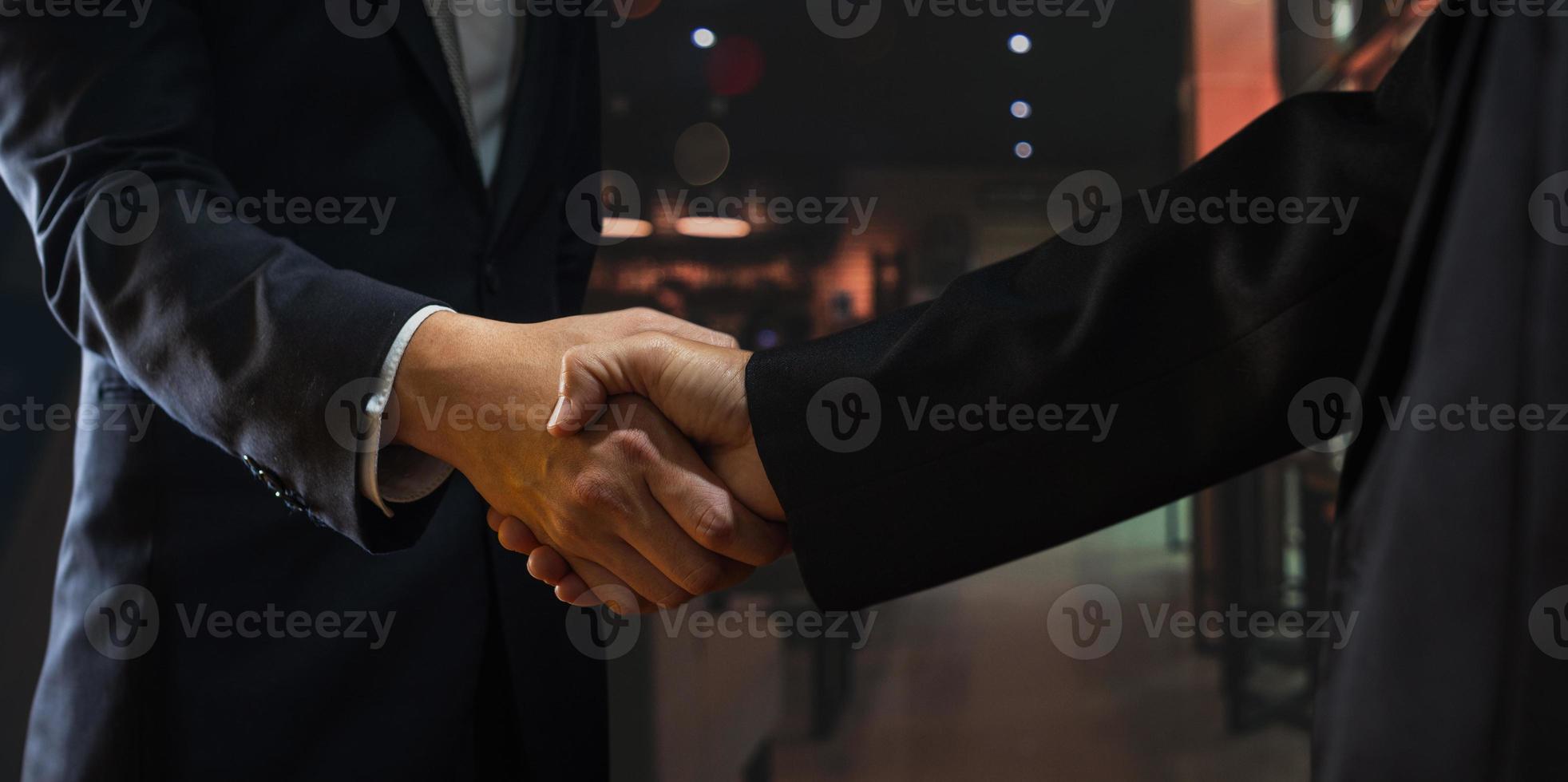 två personer skakar hand med suddig restaurangbakgrund foto