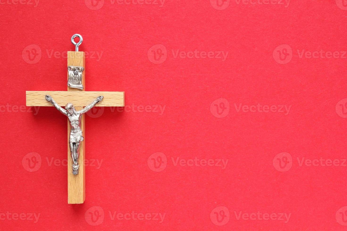 krucifix kristen trä- korsa på röd bakgrund. katolik symbol. flatlay, topp se, lägga ut, isolerat. be för Gud, tro i Jesus christ och tro religion begrepp. närbild foto