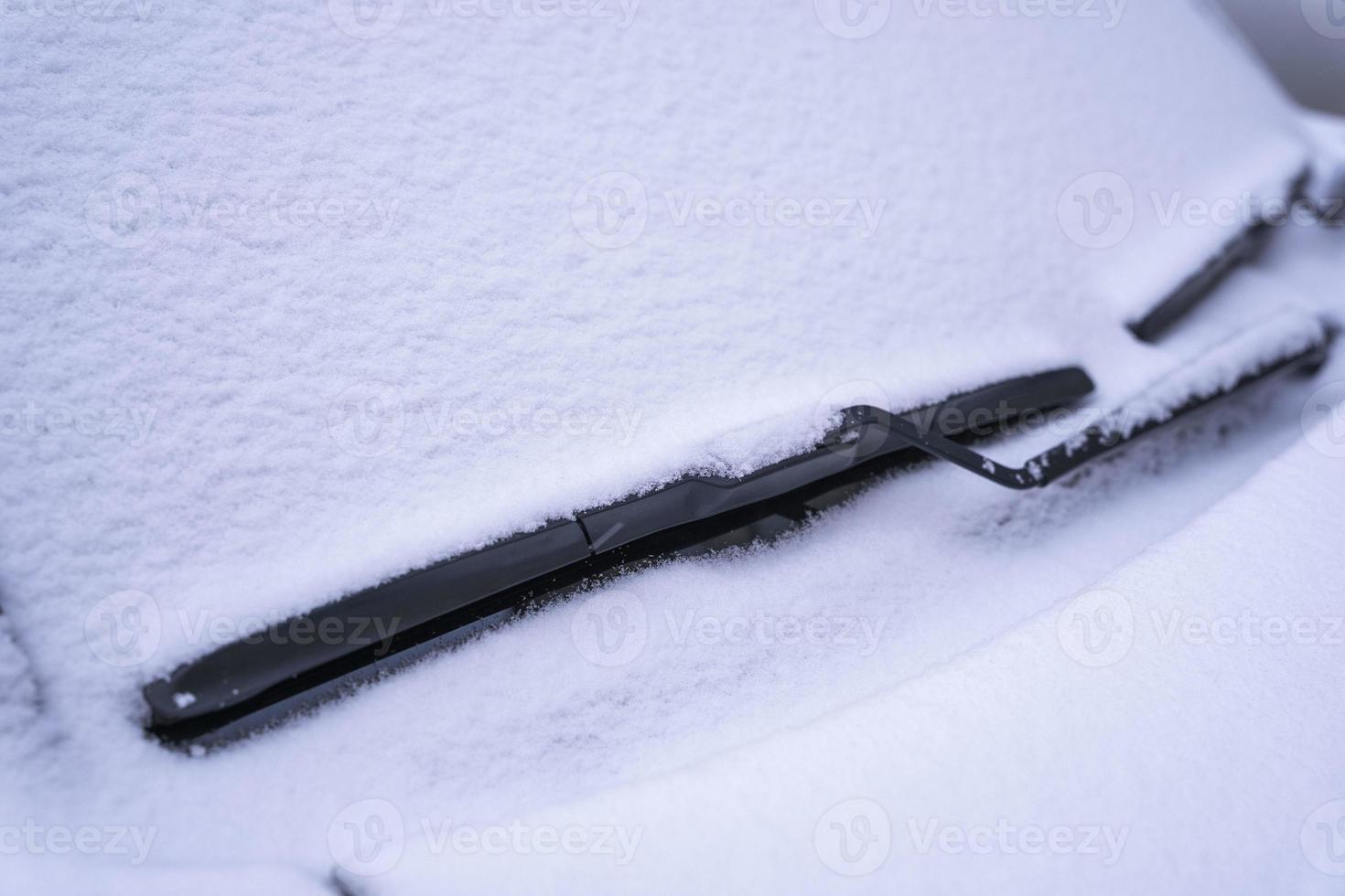snötäckt bil vindskydd, torkare blad i fluffig först snö foto