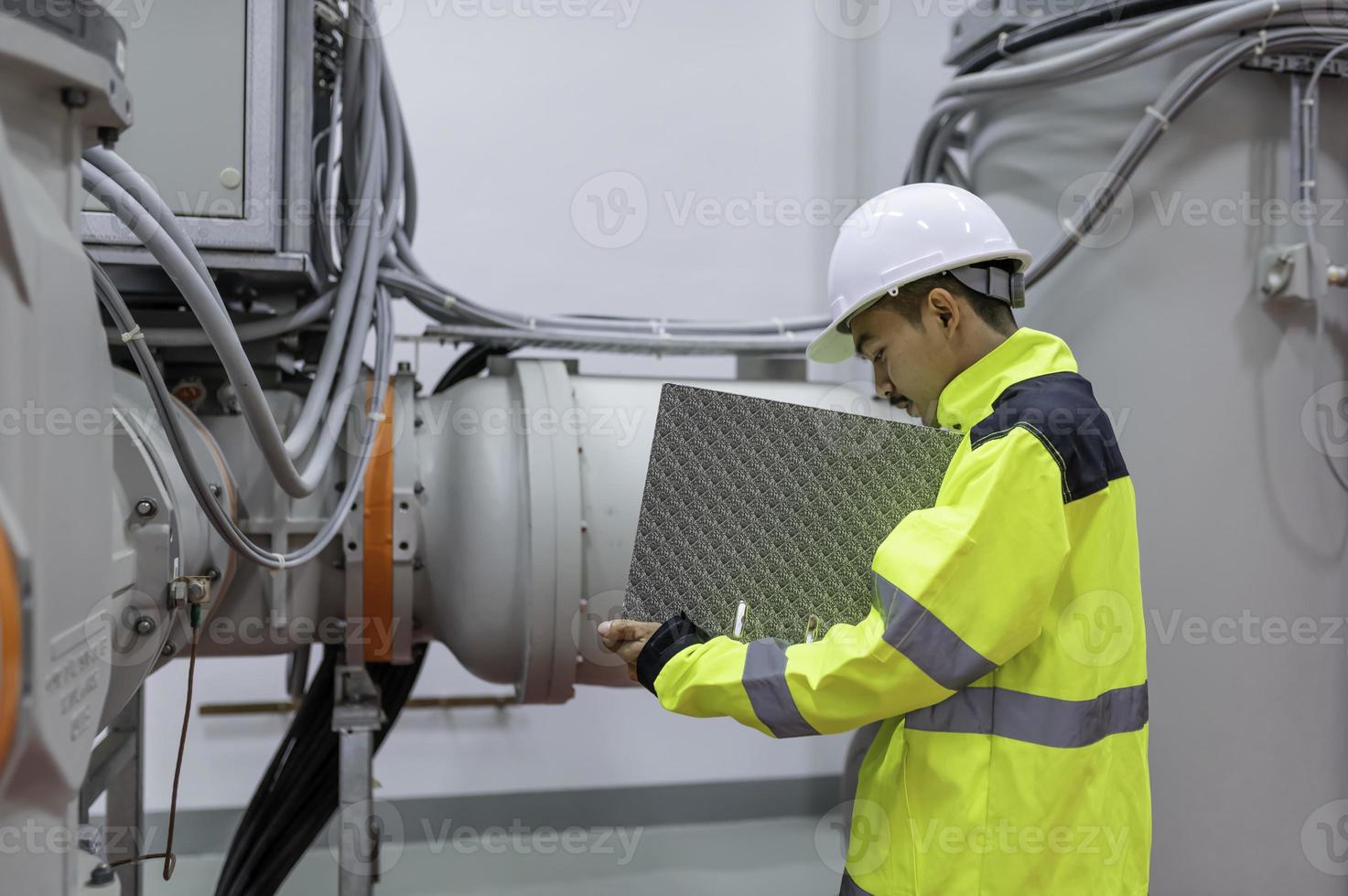 elektrisk ingenjör man kontroll Spänning på de kraft distribution skåp i de kontrollera rum, förebyggande underhåll årligen, thailand elektriker arbetssätt på företag foto