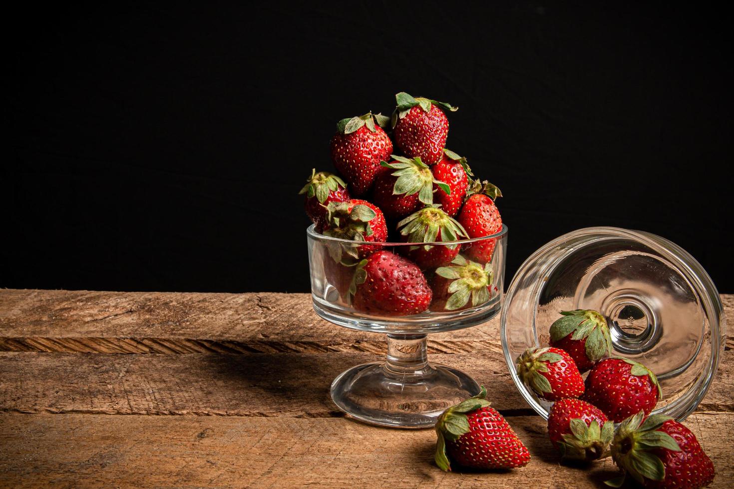 jordgubbar i ett glas på ett träbord foto