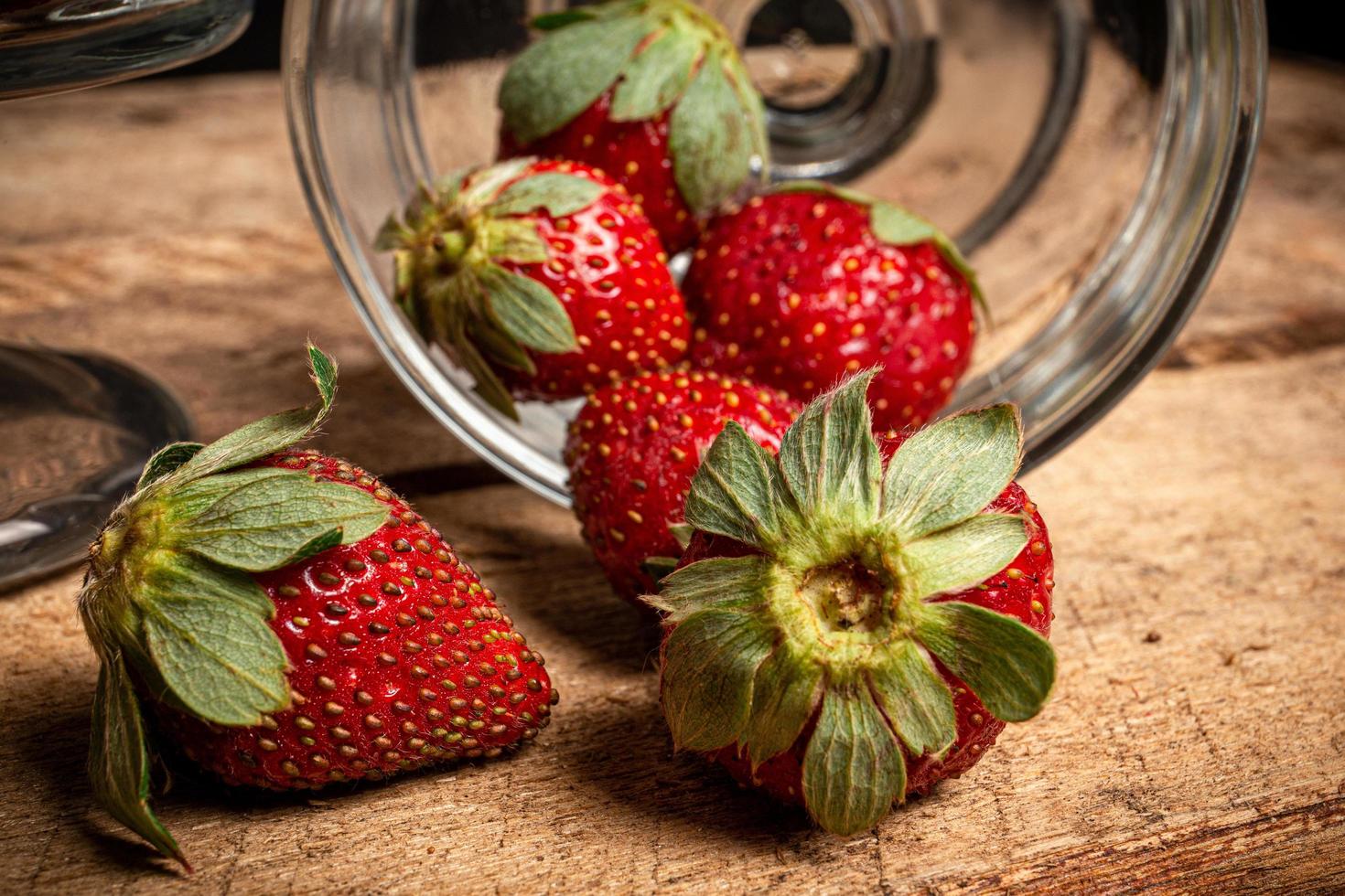 jordgubbar i ett glas på ett träbord foto