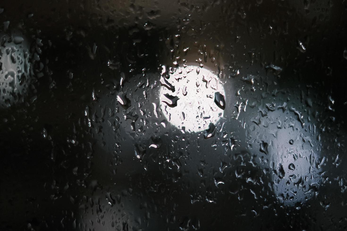 regndroppar fläck i regnig natt fönster foto