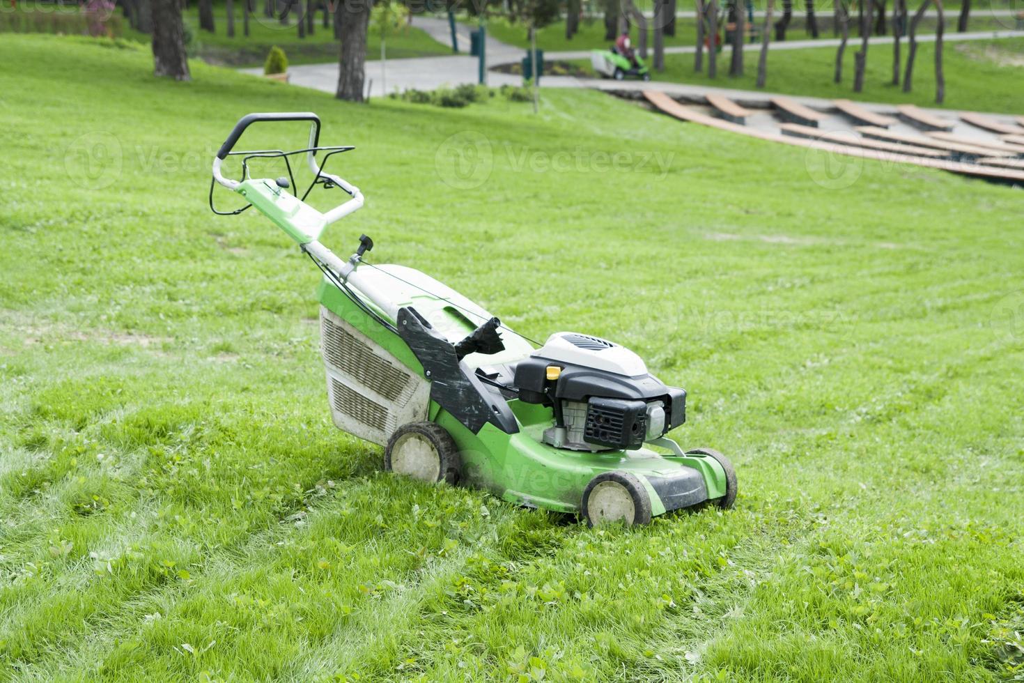 gräsmatta gräsklippare på grön gräs i de parkera foto