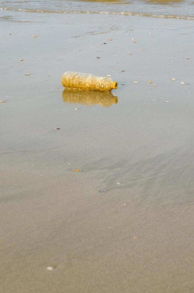 plast flaska avfall på strand för förorening begrepp foto