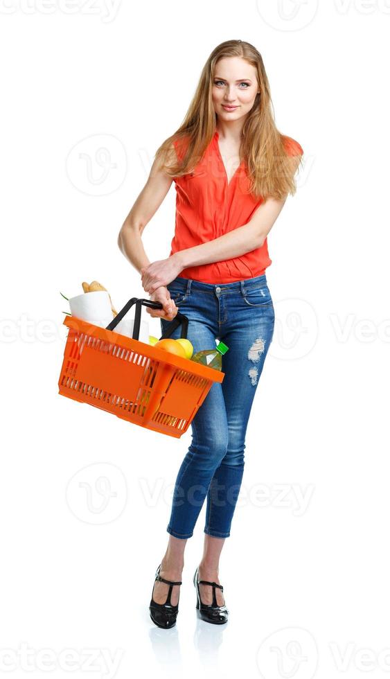 Lycklig kvinna innehav en korg full av friska mat. handla foto