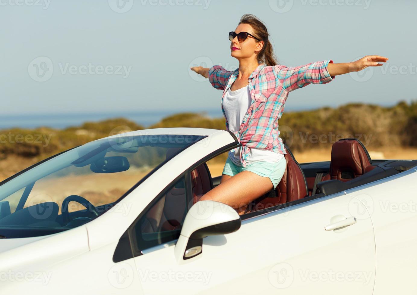 frihet - Lycklig fri kvinna i cabriolet glädjande glad med vapen Uppfostrad foto