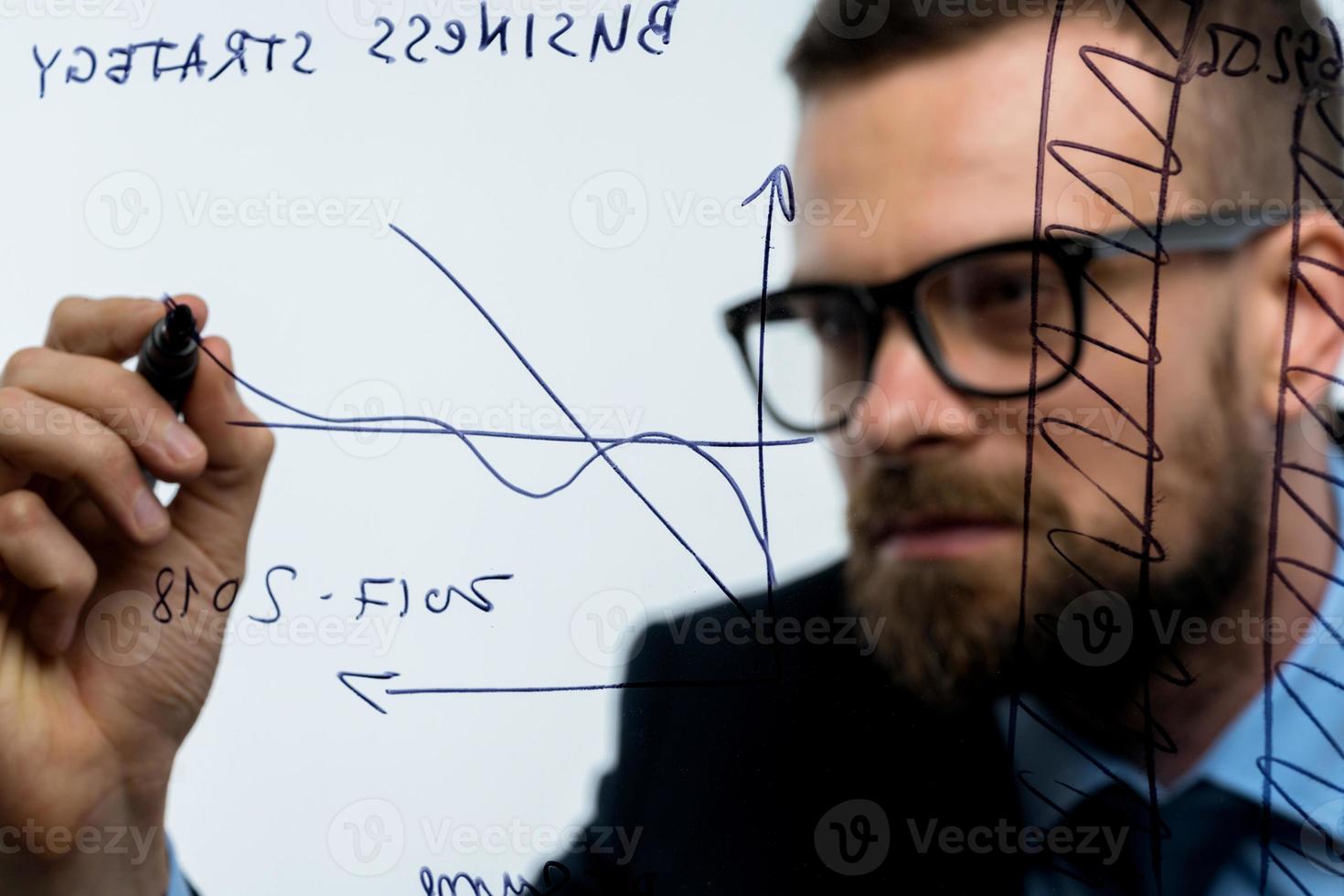 man drar olika tillväxt diagram, beräknande framtidsutsikter för Framgång i en modern glas kontor foto