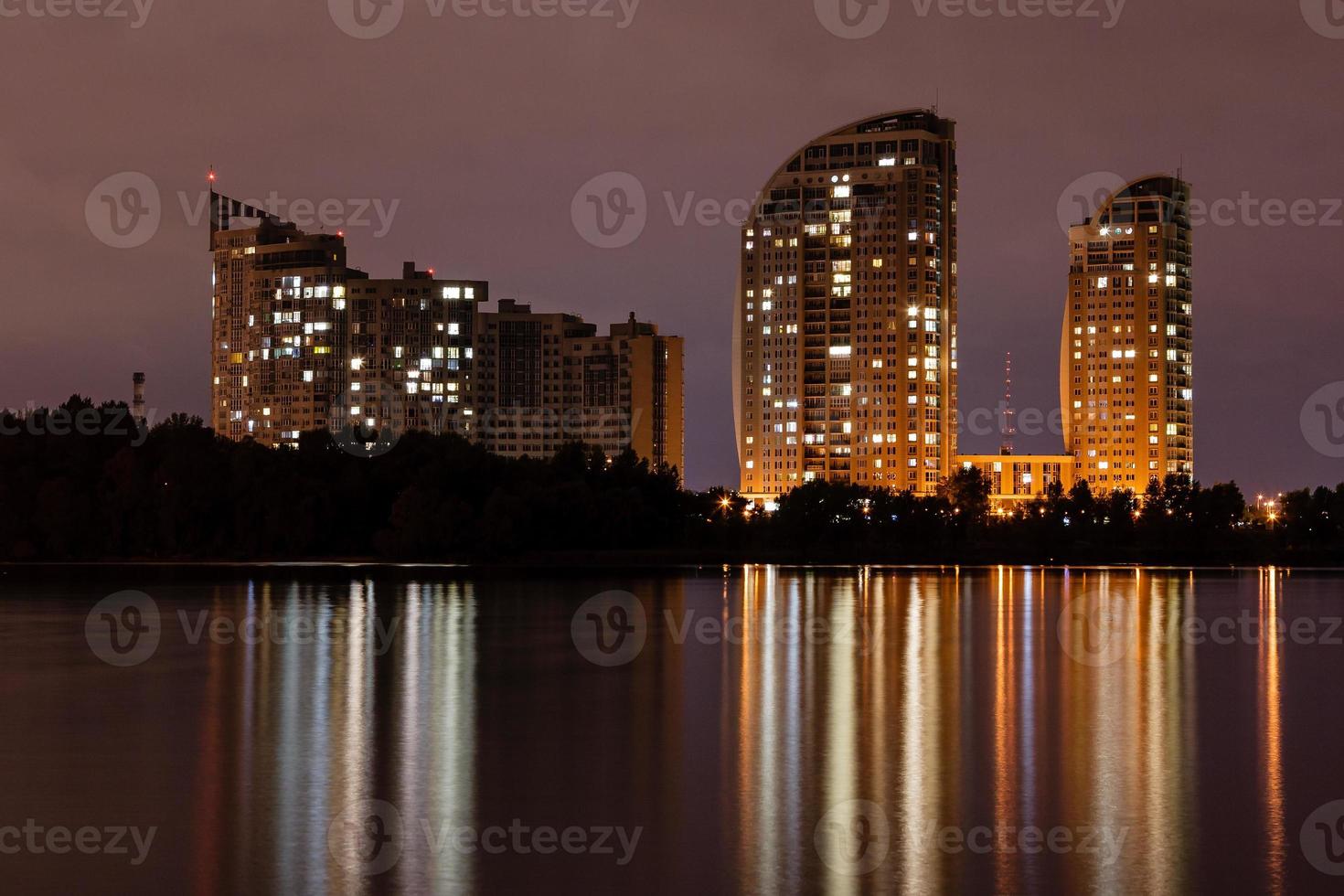 natt stad med reflexion av hus i de flod foto