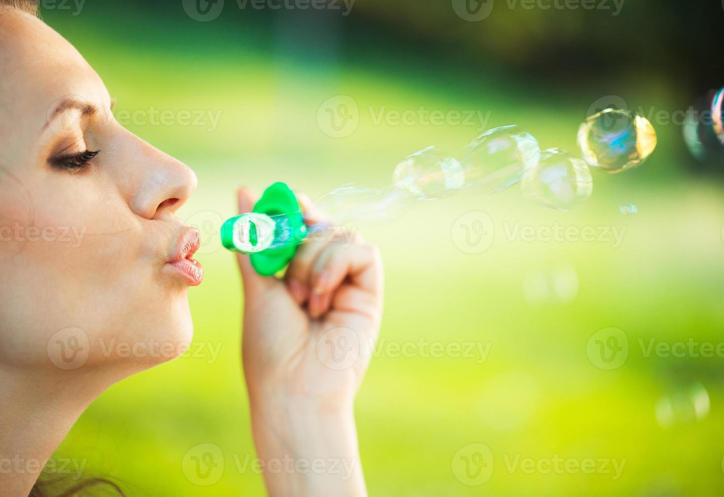flicka blåser tvål bubblor i de parkera foto